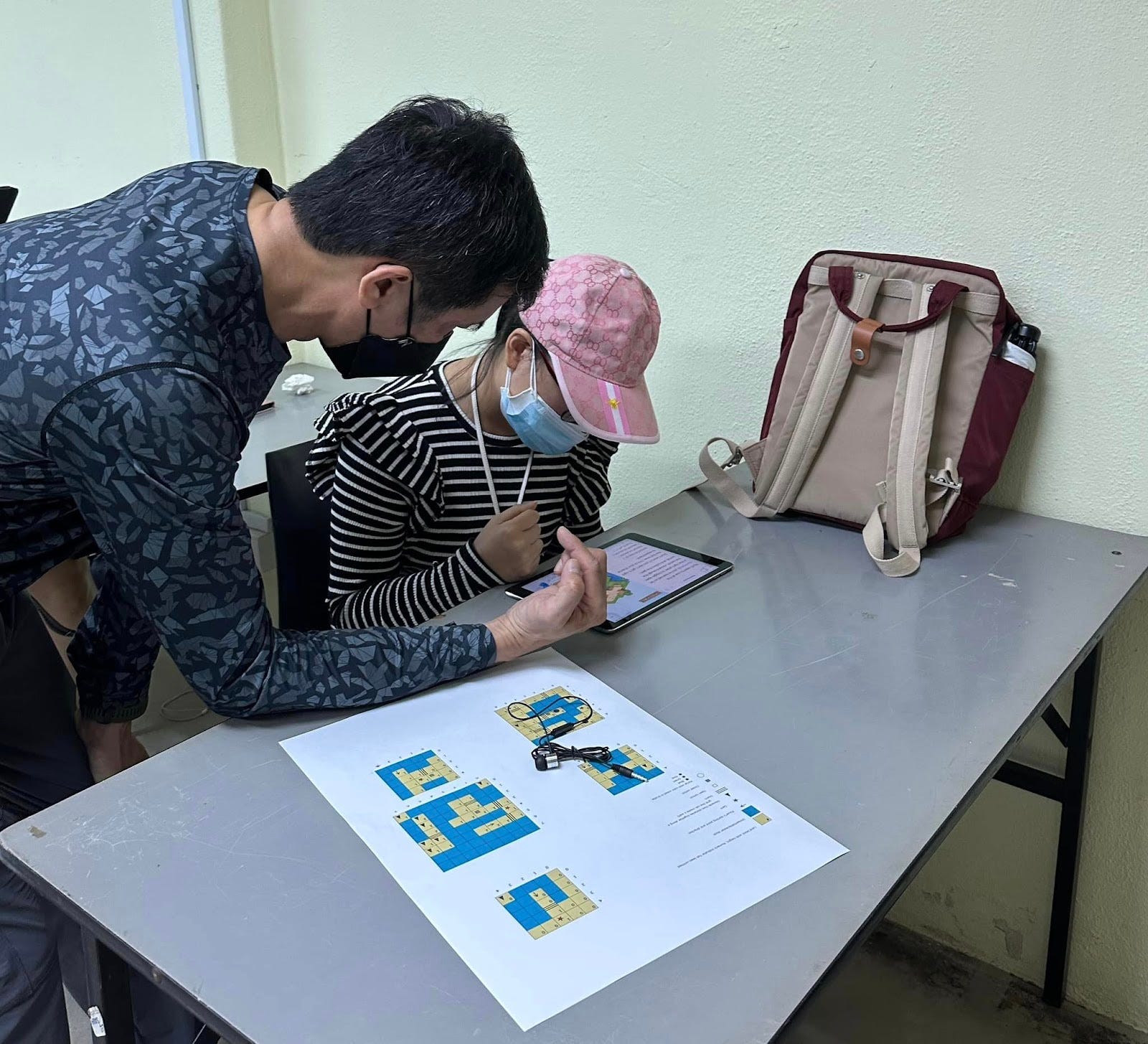 A participant using a real-life visual map to access each 3D world puzzle away from the iPad screen.