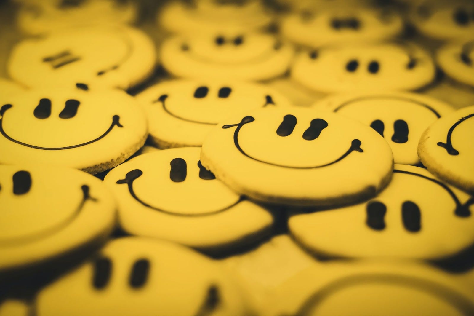 Rows of yellow smiley-face tokens representing human emotion and empathy.