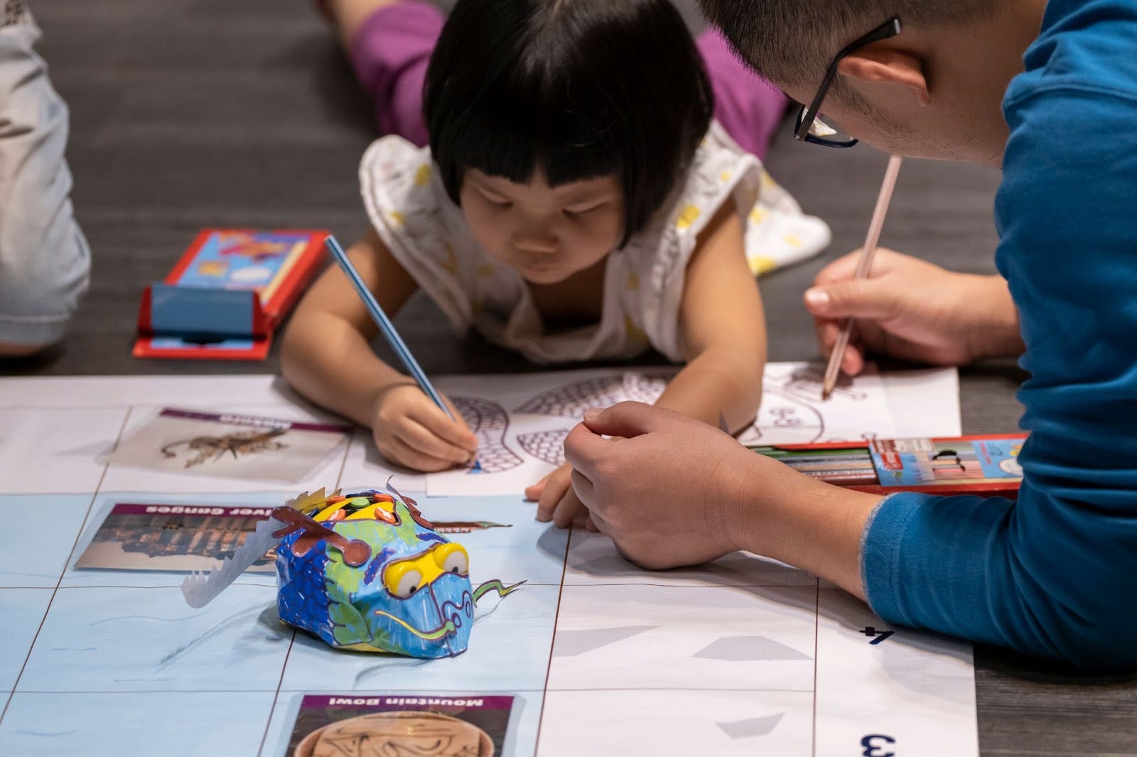 Child and adult colour worksheets together beside a handmade Bee-Bot outfit.