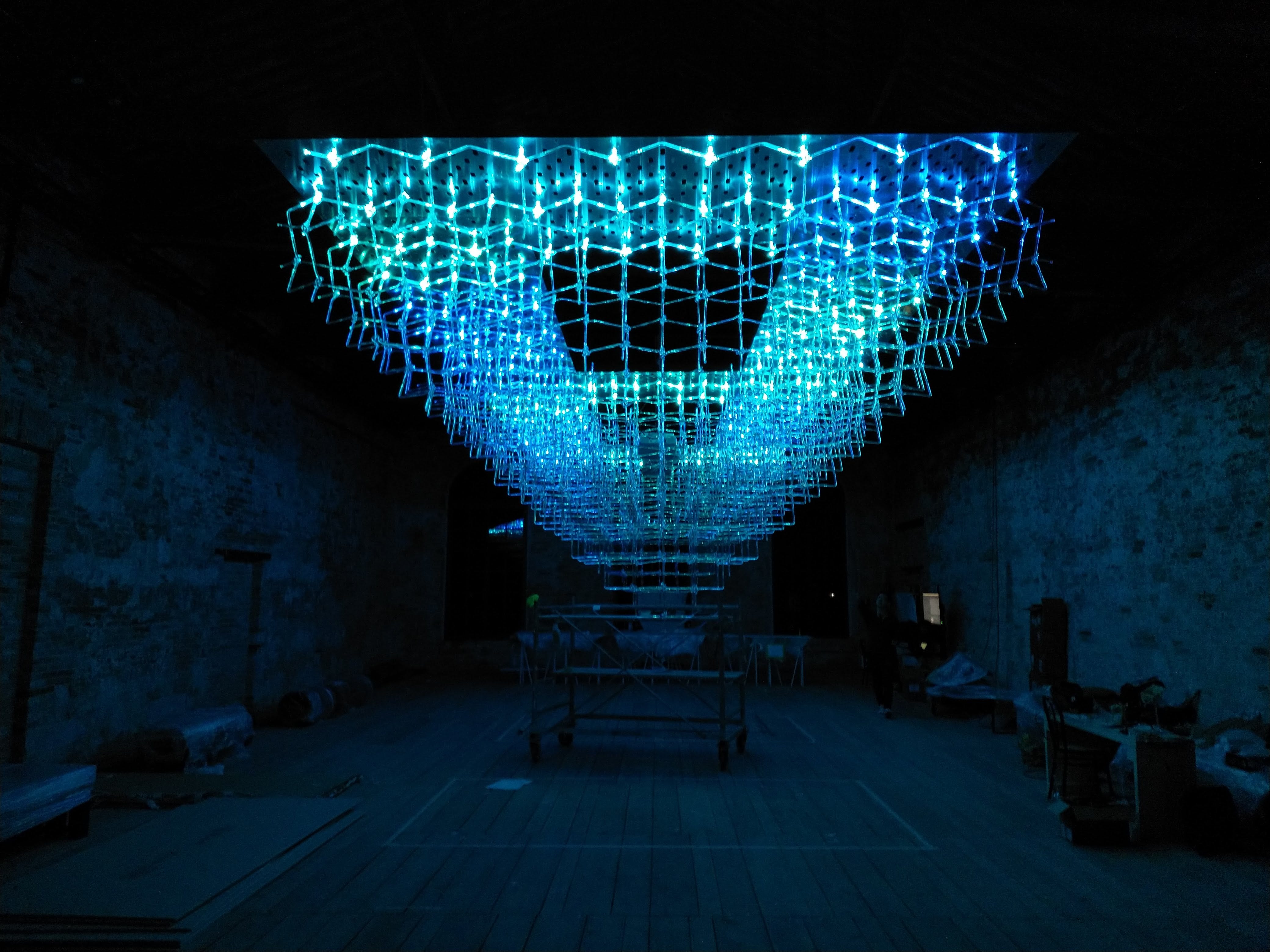 Suspended grid of cyan lights glowing in disco mode over the exhibit