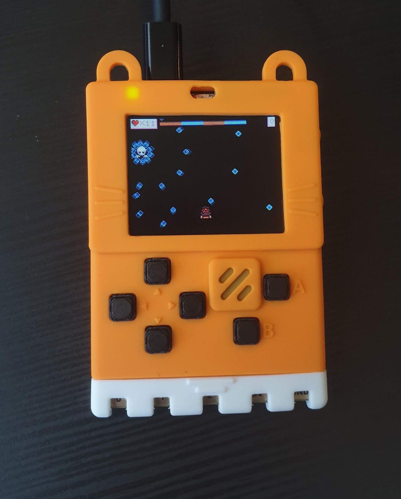 Orange Meow:bit handheld console running a pixel-art game with a heart counter.