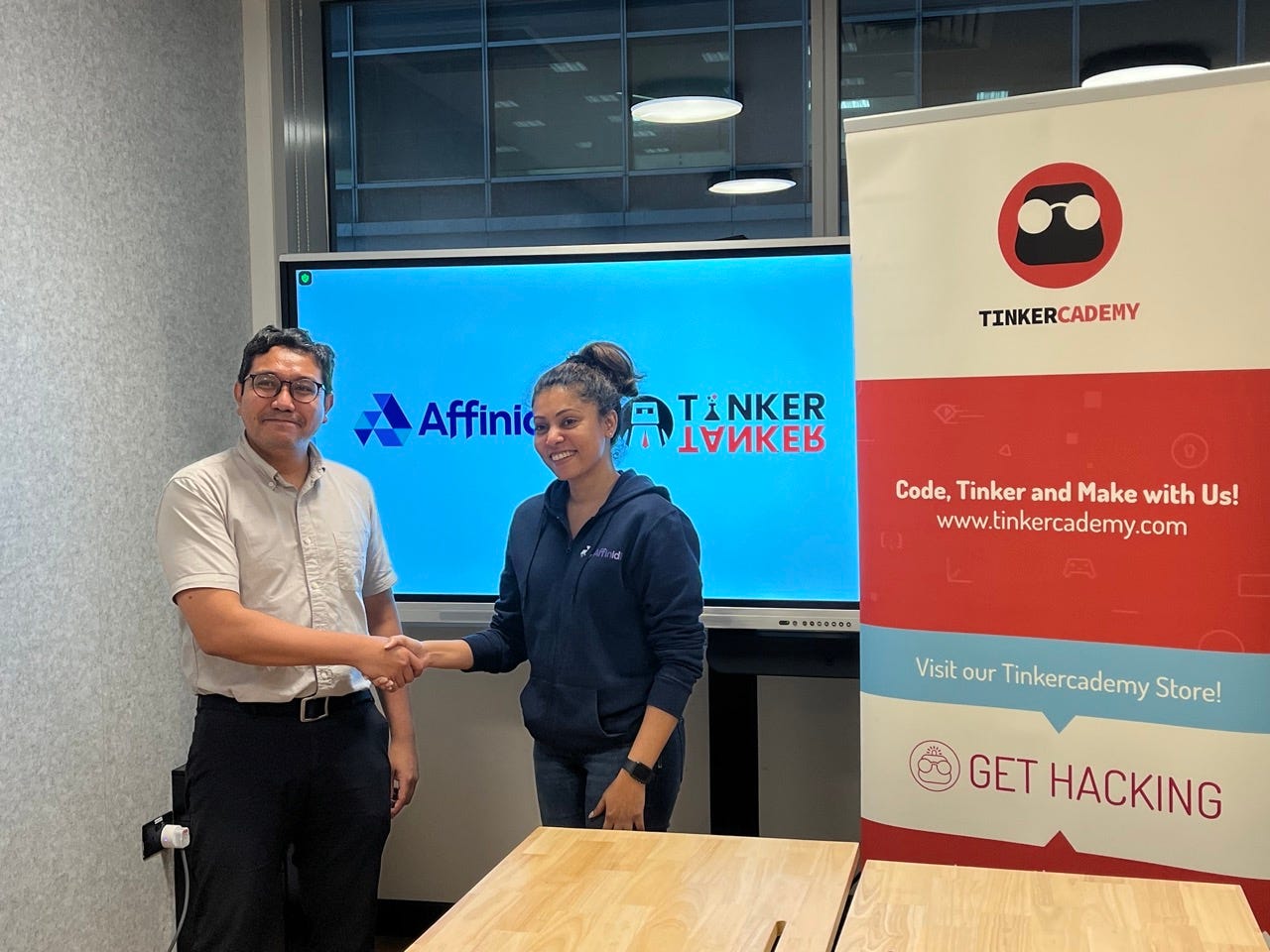 Tinkercademy co-founder, Akmal (left) shaking hands with Varsha, General manager of Affinidi (right).