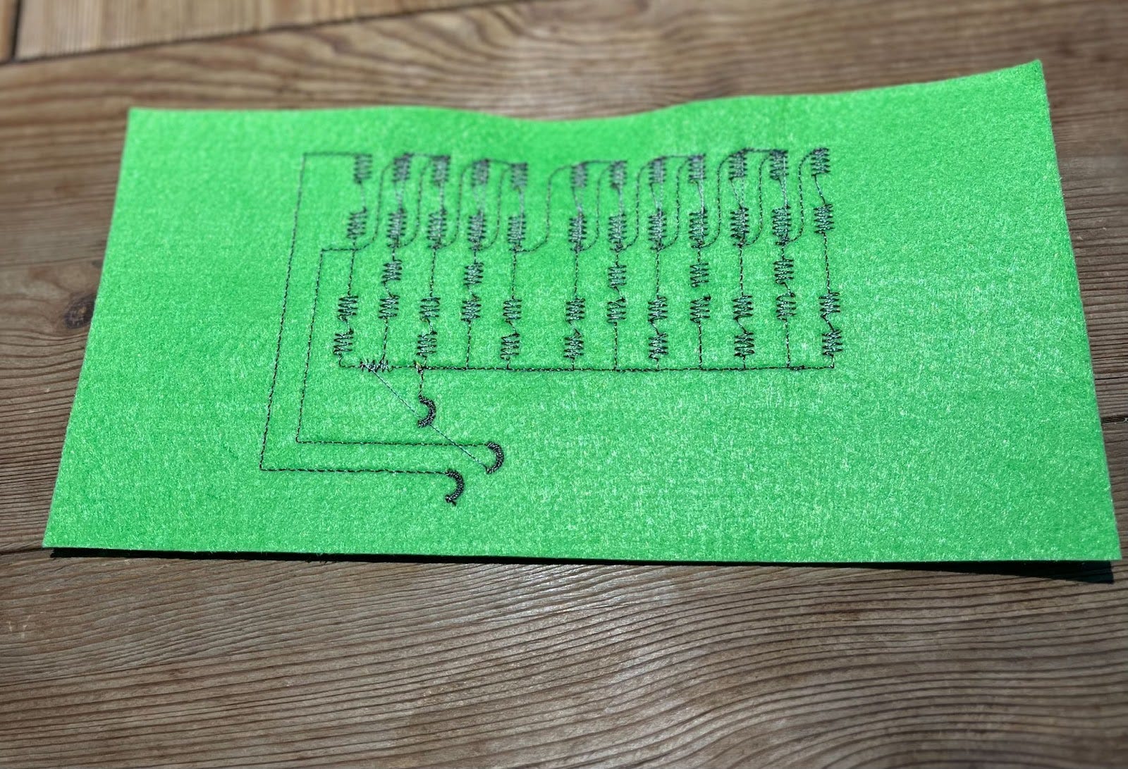 Conductive thread embroidered onto fabric to form a circuit.