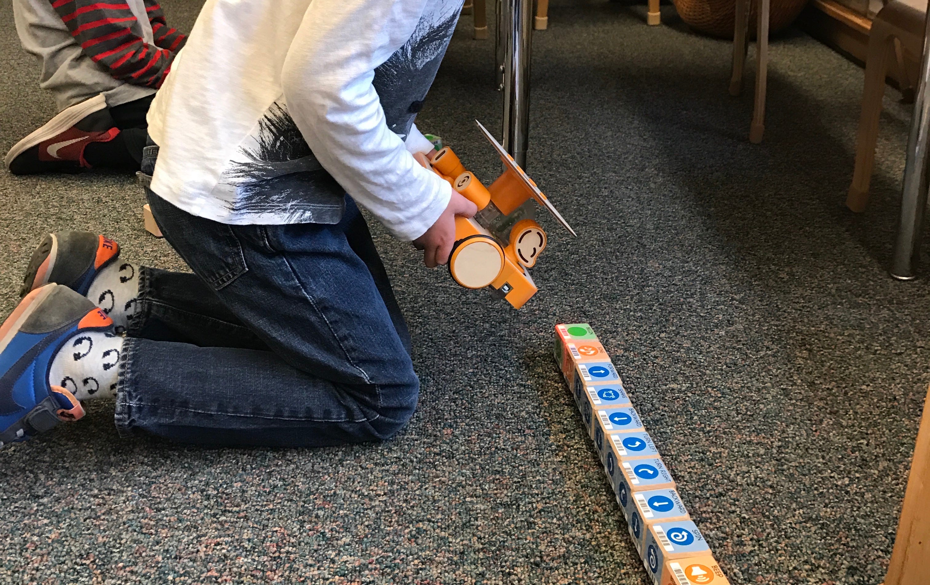 A student programming KIBO by scanning (literal) code blocks