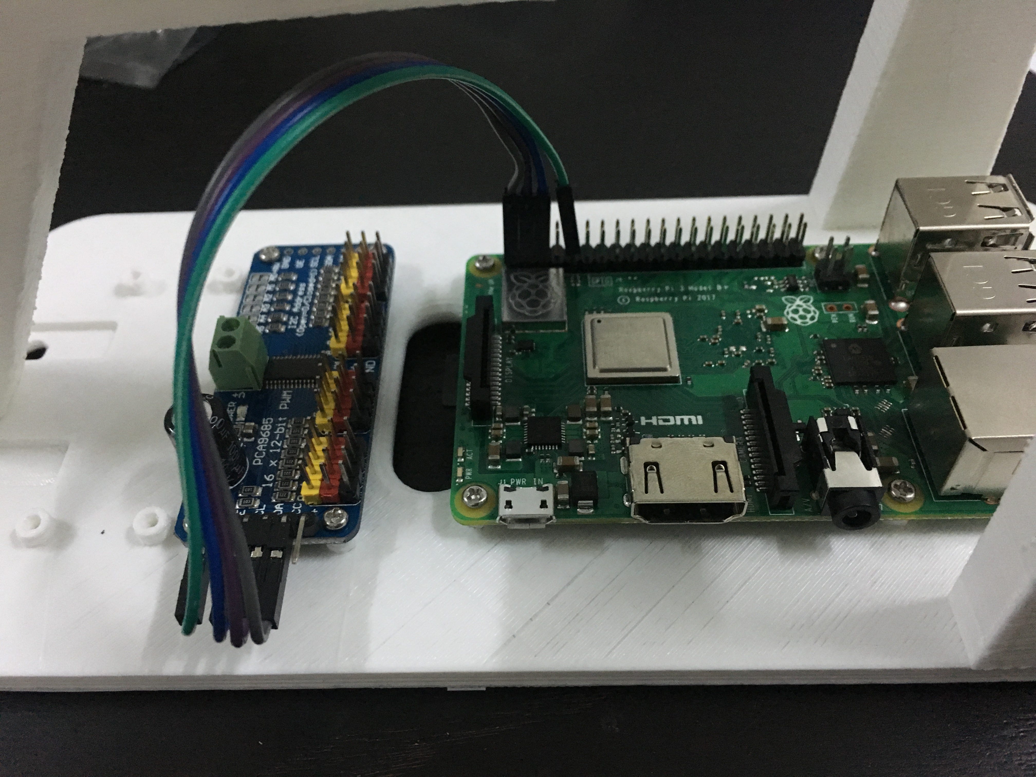 Servo driver beside the Raspberry Pi, connected with jumper wires